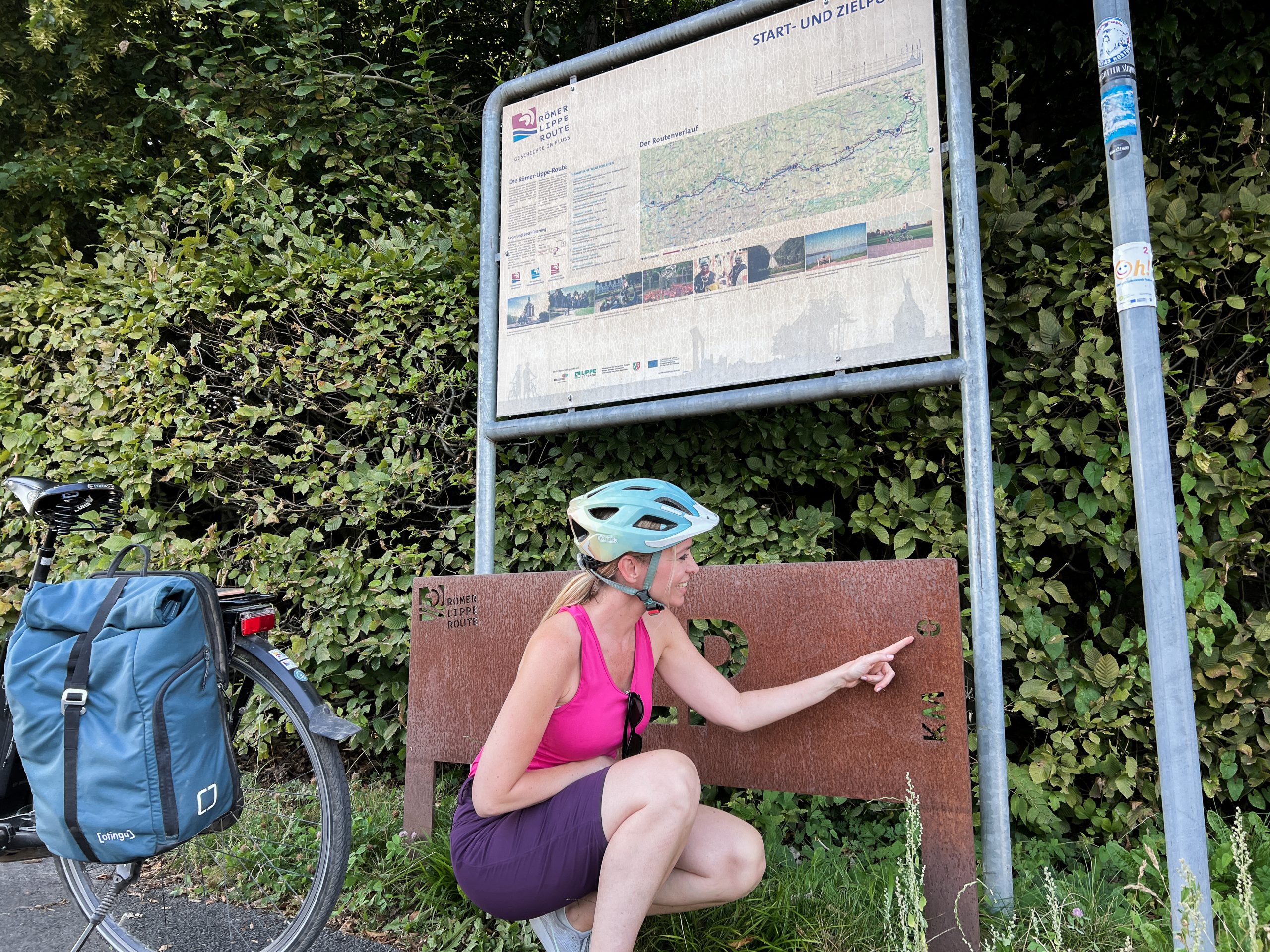 Das Foto zeigt Sandra an einer Kilometertafel auf der Römer-Lippe-Route
