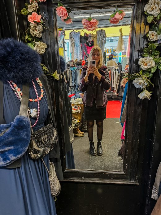 Auf dem Foto ist der Second Hand Store Misfits in Bochum von innen zu sehen und eine Frau die sich im Spiegel fotografiert.